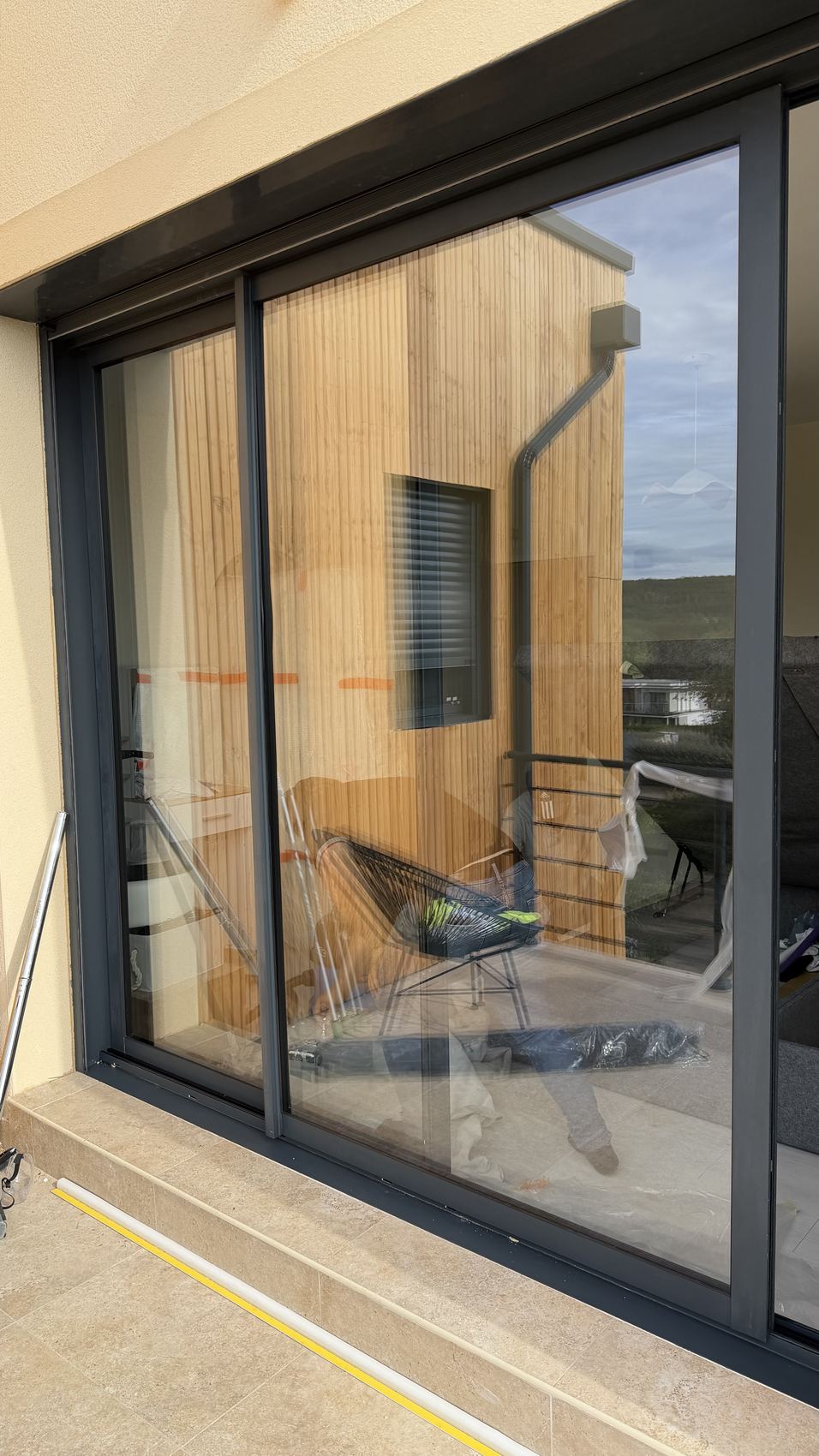 Baie vitrée coulissante propre, la façade en bois s'y reflète