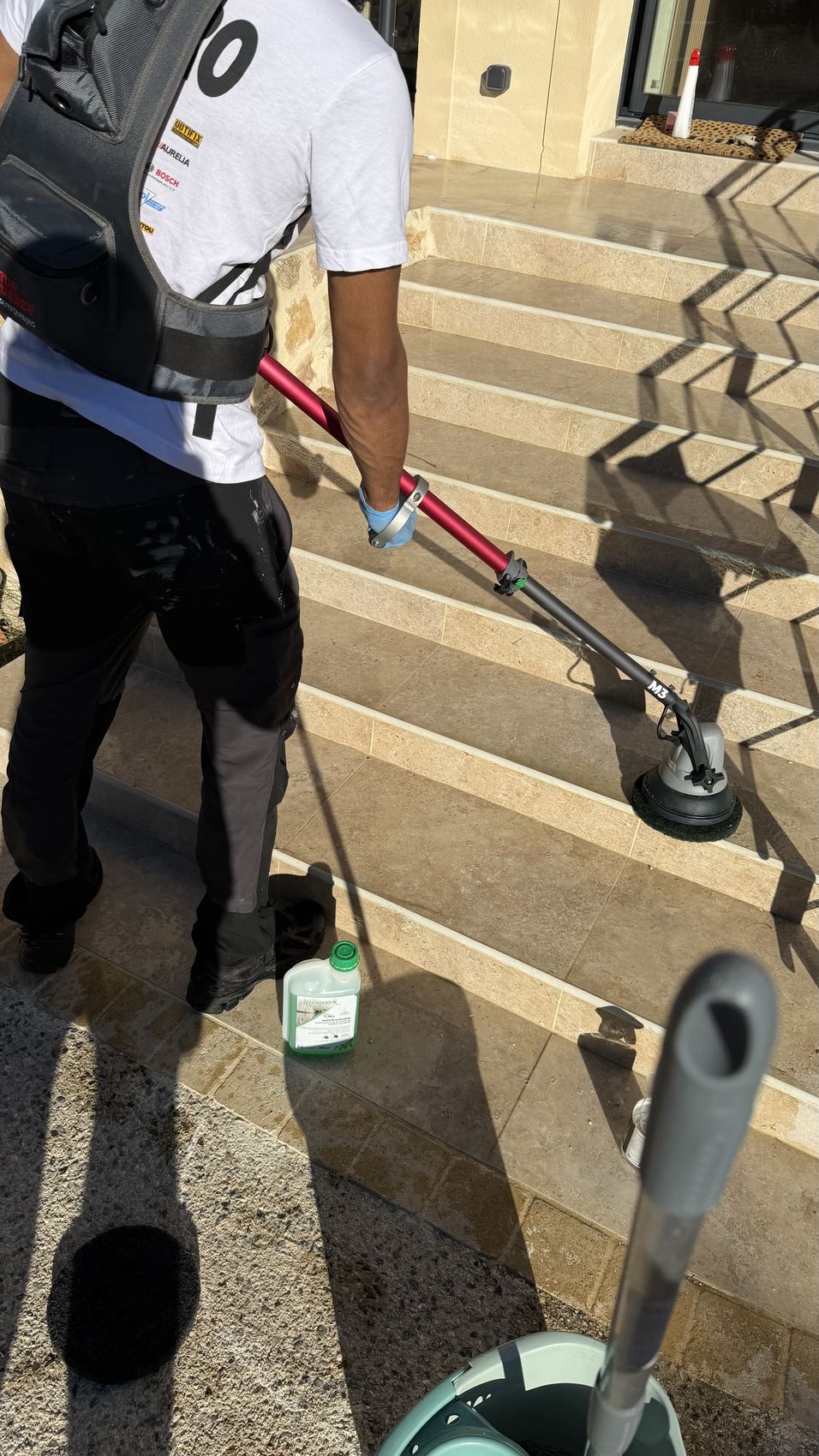 Nettoyage d'un escalier extérieur en pierre à la brosse rotative